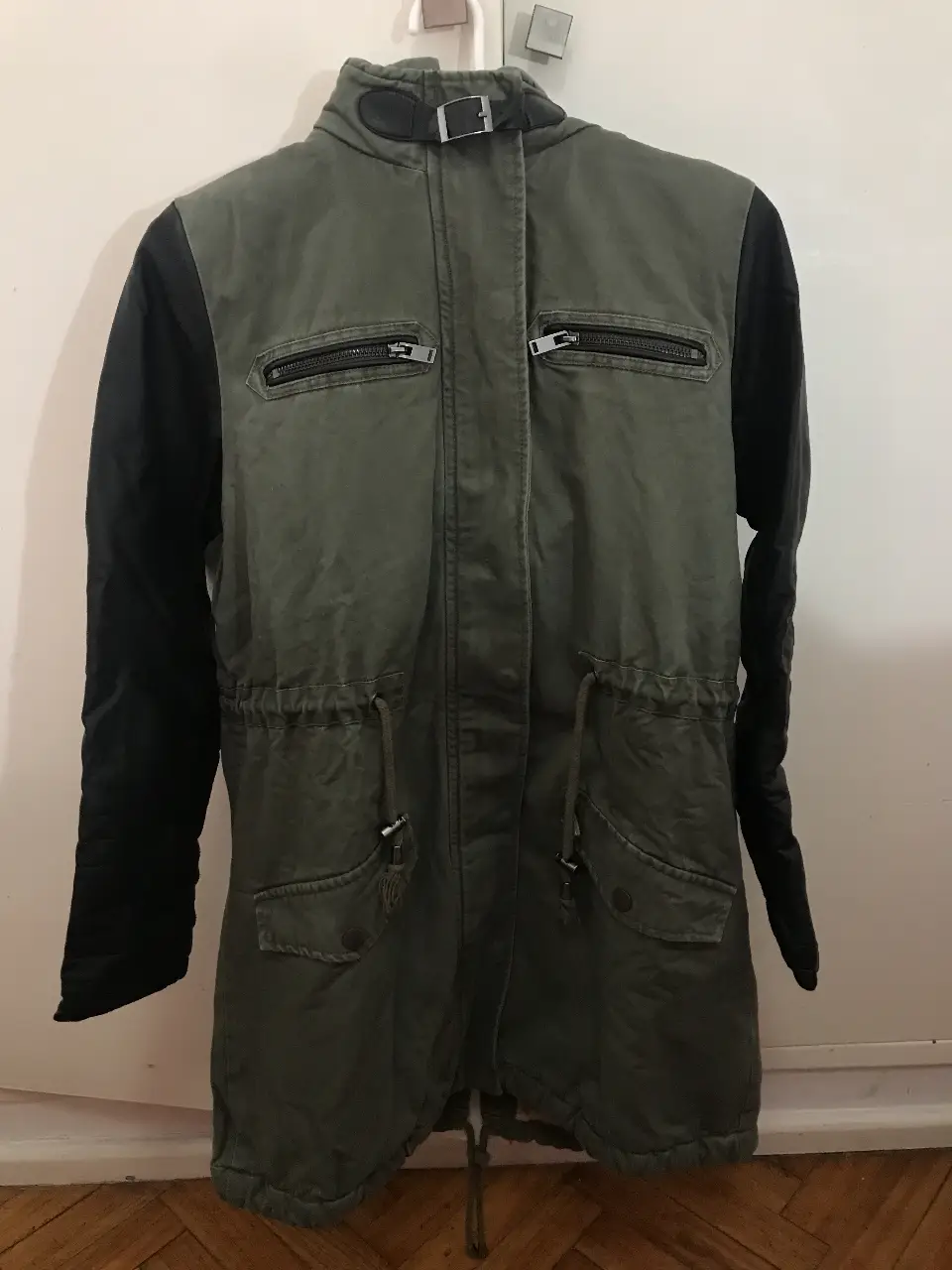 Campera parka Marca “Materia” verde militar con mangas negras. Tiene cierre frontal y bolsillos con solapa. Ideal para el invierno.