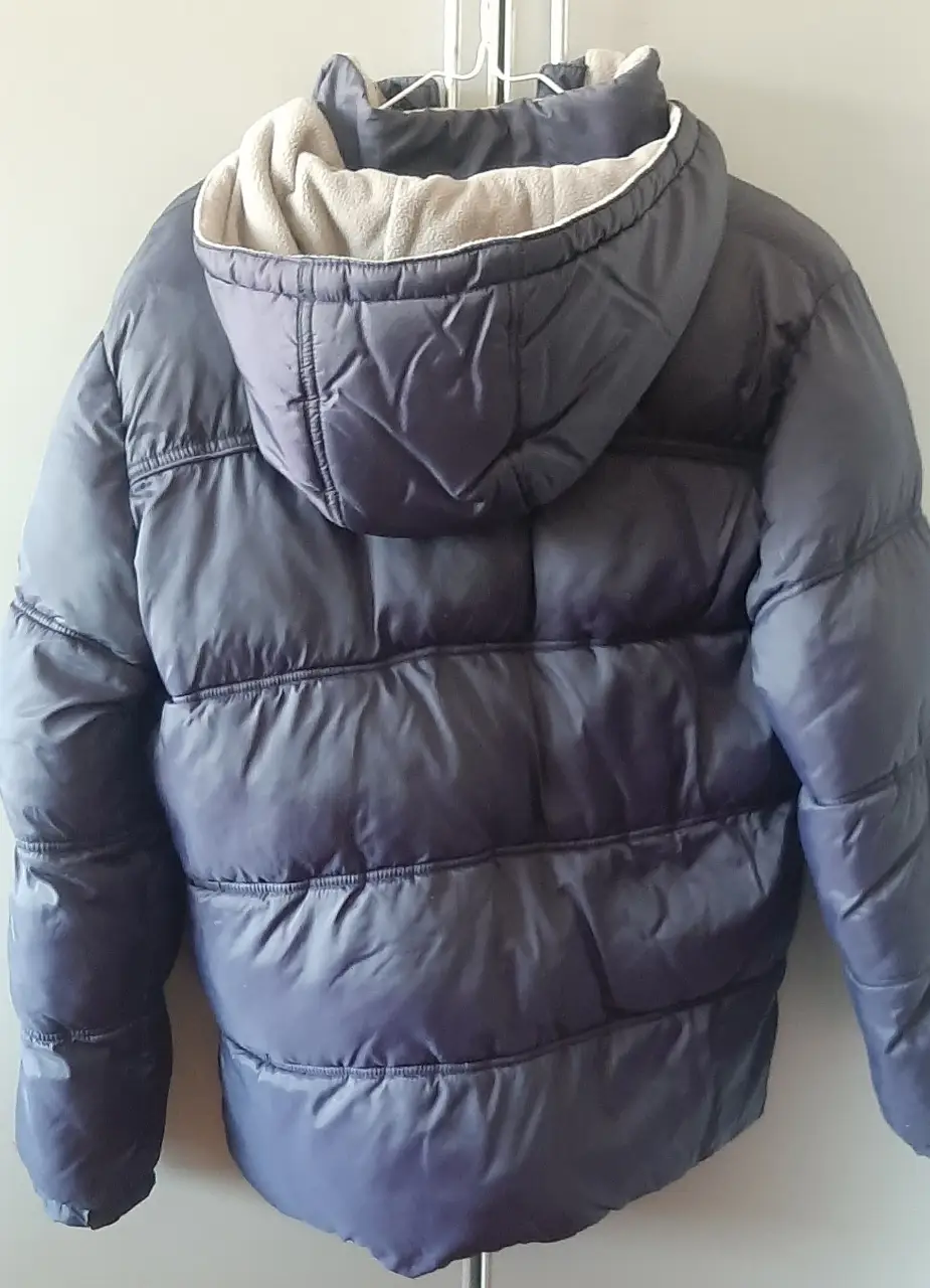 Campera de abrigo para niño, azul oscuro, con capucha y forro interior en color crema. Ideal para el invierno, con cierre y bolsillos.