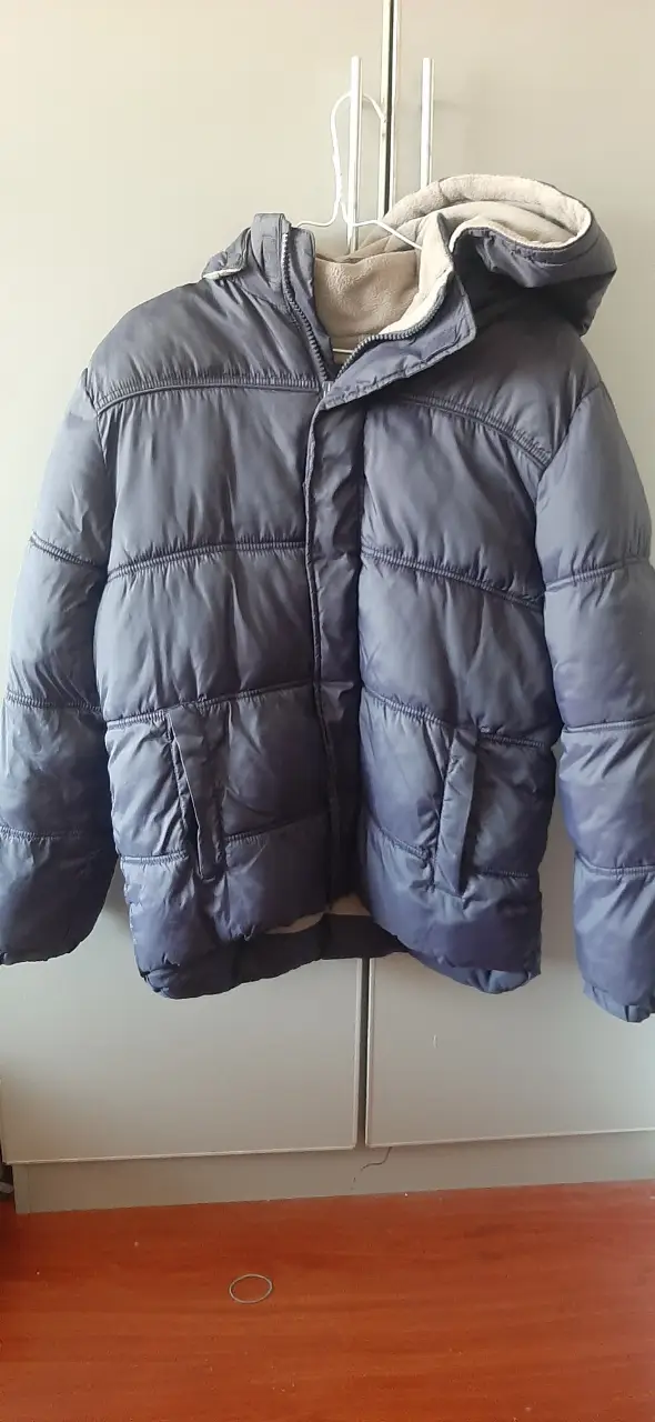 Campera de pluma azul para niño, con capucha y bolsillos. Ideal para el invierno.