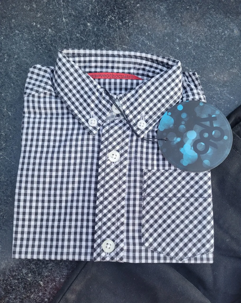 Conjunto de camisa a cuadros vichy en blanco y negro con mangas cortas y pantalón negro liso. Ideal para un look casual y canchero para los más chicos.
