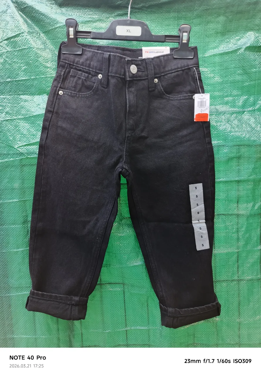 Jean negro con puños doblados. Posee bolsillos delanteros y traseros.