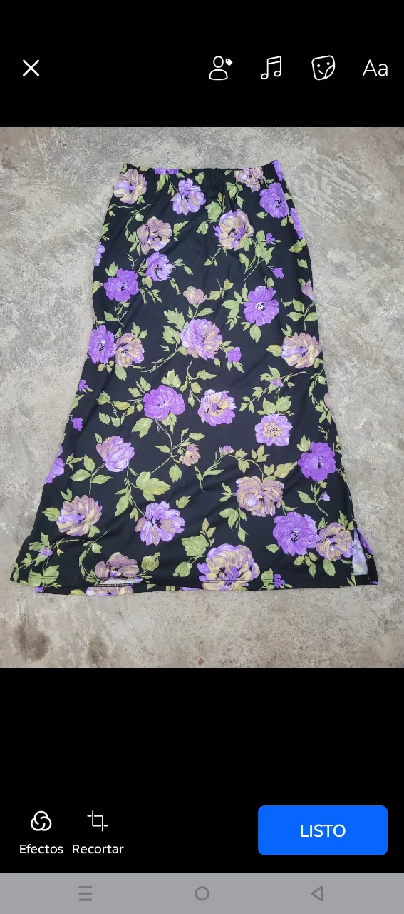 Pollera larga estampada con flores en tonos violetas y verdes sobre fondo negro. Posee un corte lateral y cintura elastizada, lo que la hace súper cómoda y versátil. Ideal para un look casual o boho chic.