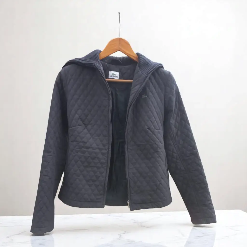 Campera negra acolchada de la marca Lacoste. Ideal para el invierno, con cierre y un diseño clásico. Medidas h a h 36 cm sisa 41 cm cintura 38 cm largo manga 60 cm largo 57 cm