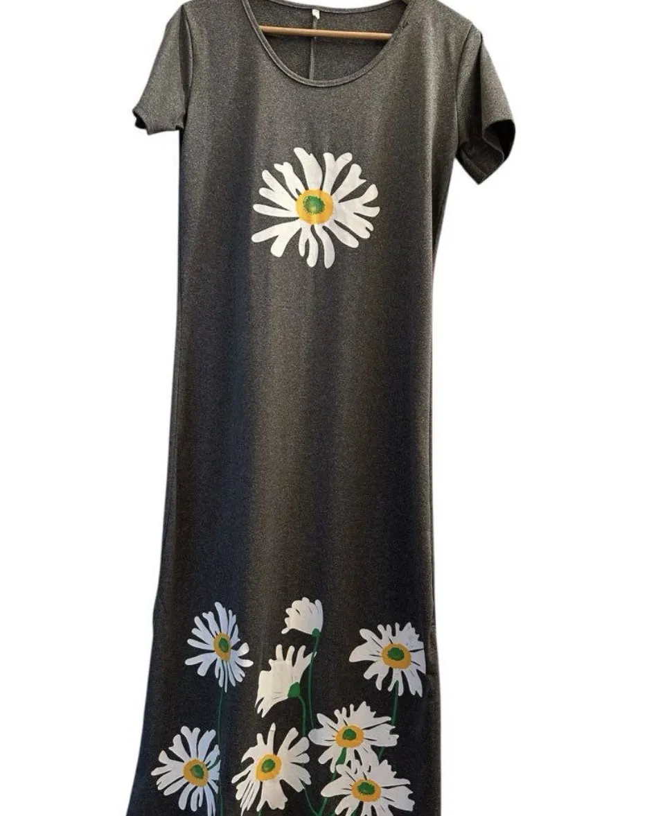 Vestido largo gris oscuro con estampa de margaritas blancas. Tiene mangas cortas y cuello redondo. Ideal para un look casual y cómodo.