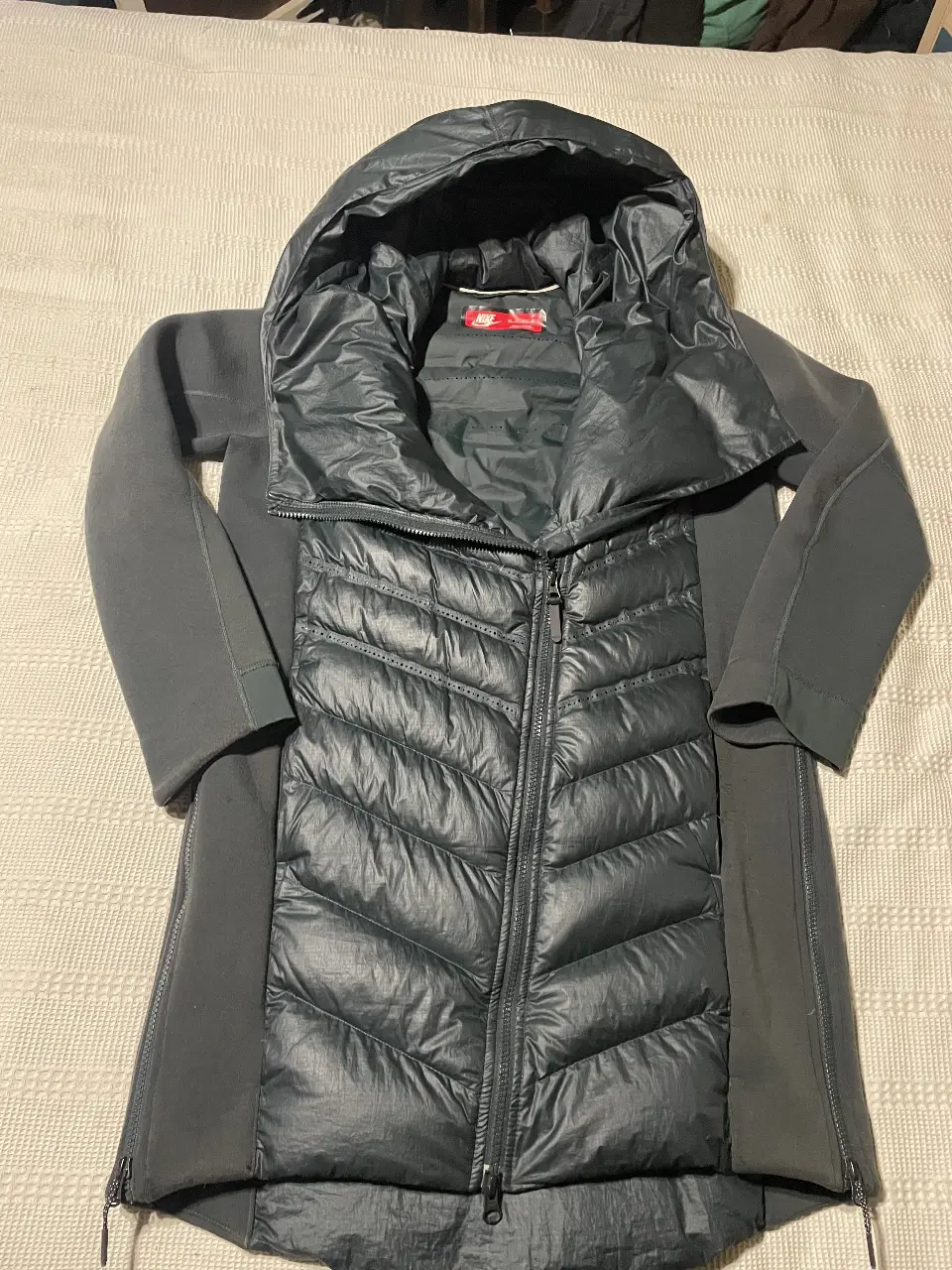 Campera de pluma Nike para hombre, color gris oscuro, con capucha y cierre frontal. Ideal para el invierno.