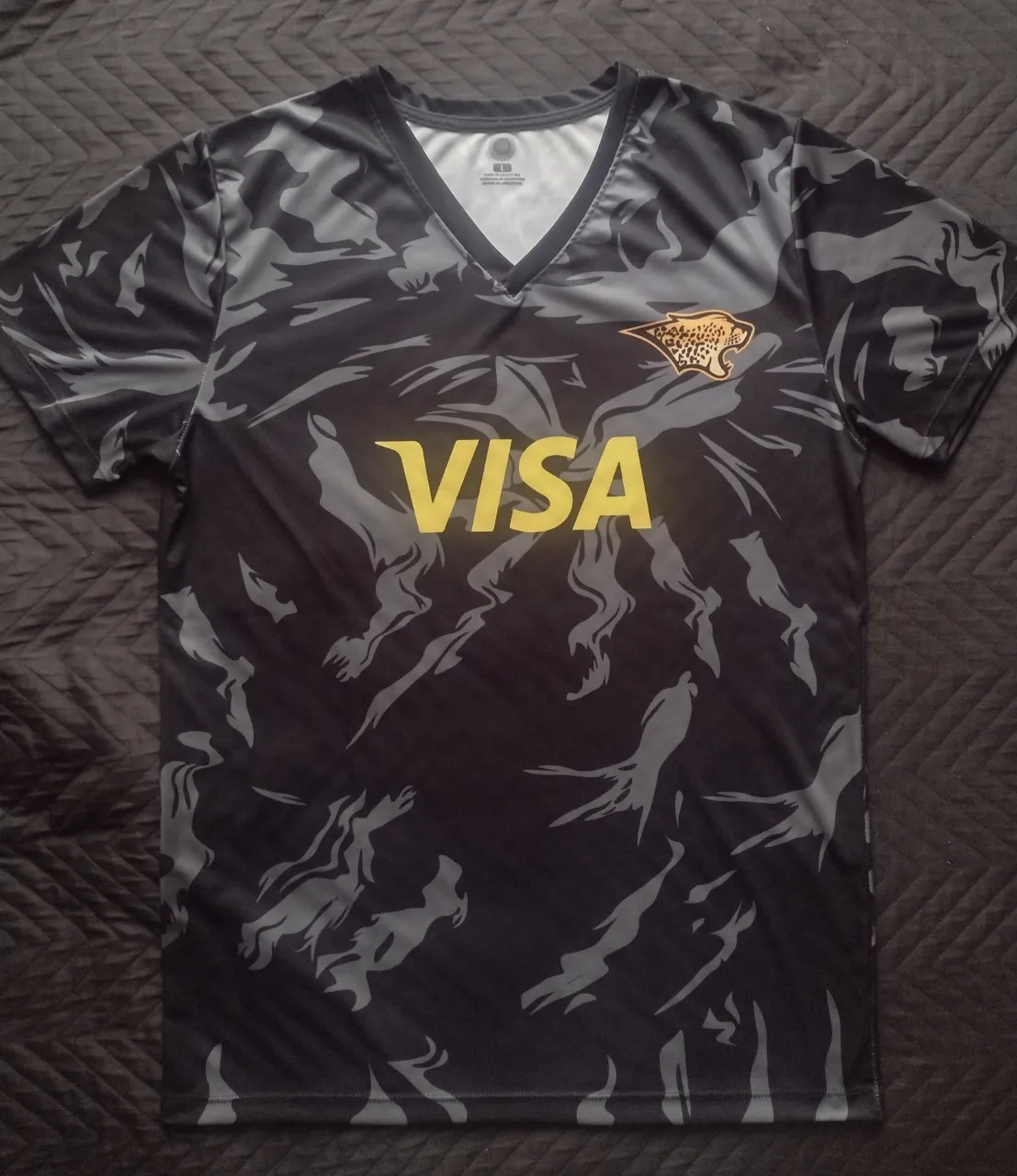 Remera deportiva de Jaguares con estampado camuflado en tonos de gris y negro ideal para entrenamiento o casual. 