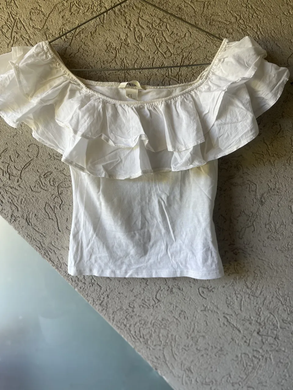 Remera blanca con volados en el escote. Escote Bardot.