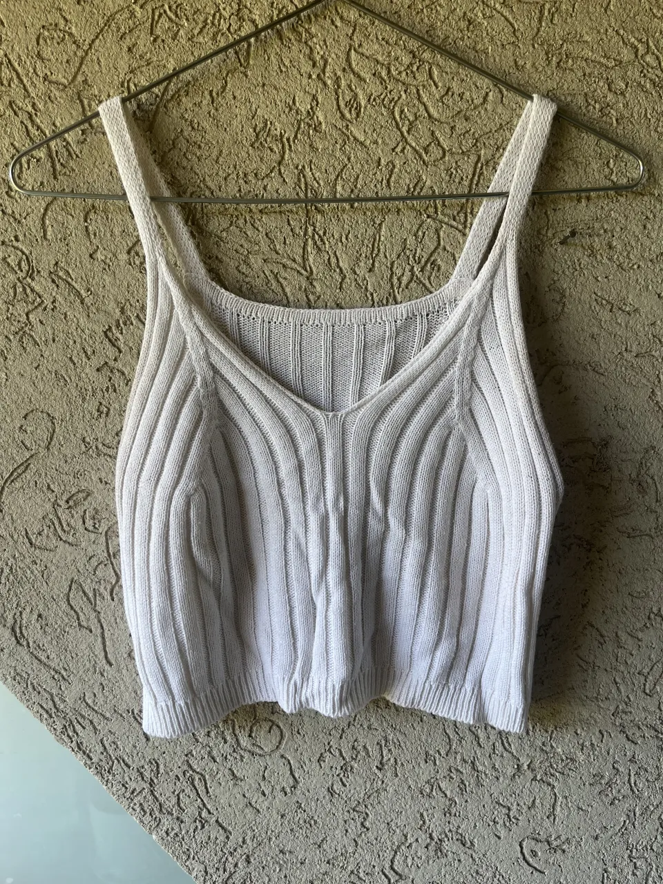 Musculosa de tejido acanalado color blanco. Posee breteles finos y escote en V.