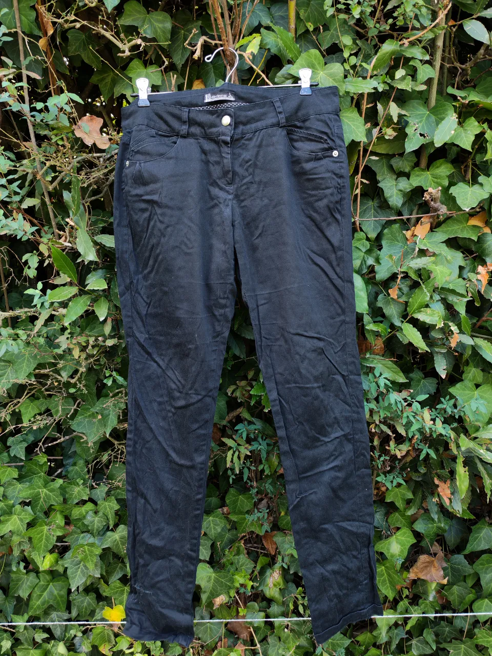 Pantalón negro de corte recto, ideal para un look casual o de trabajo. Confeccionado en un material cómodo y versátil, perfecto para el día a día. Presenta detalles de bolsillos funcionales y un cierre con botón.