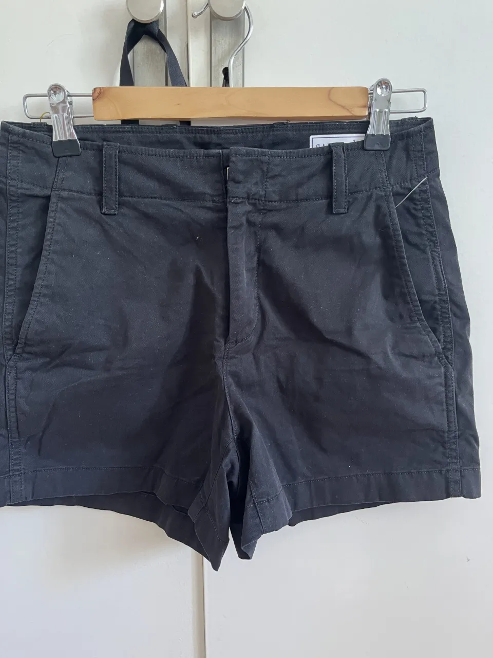Shorts de gabardina negros, tiro alto, con bolsillos y pasacintos. Ideales para un look casual y cómodo.