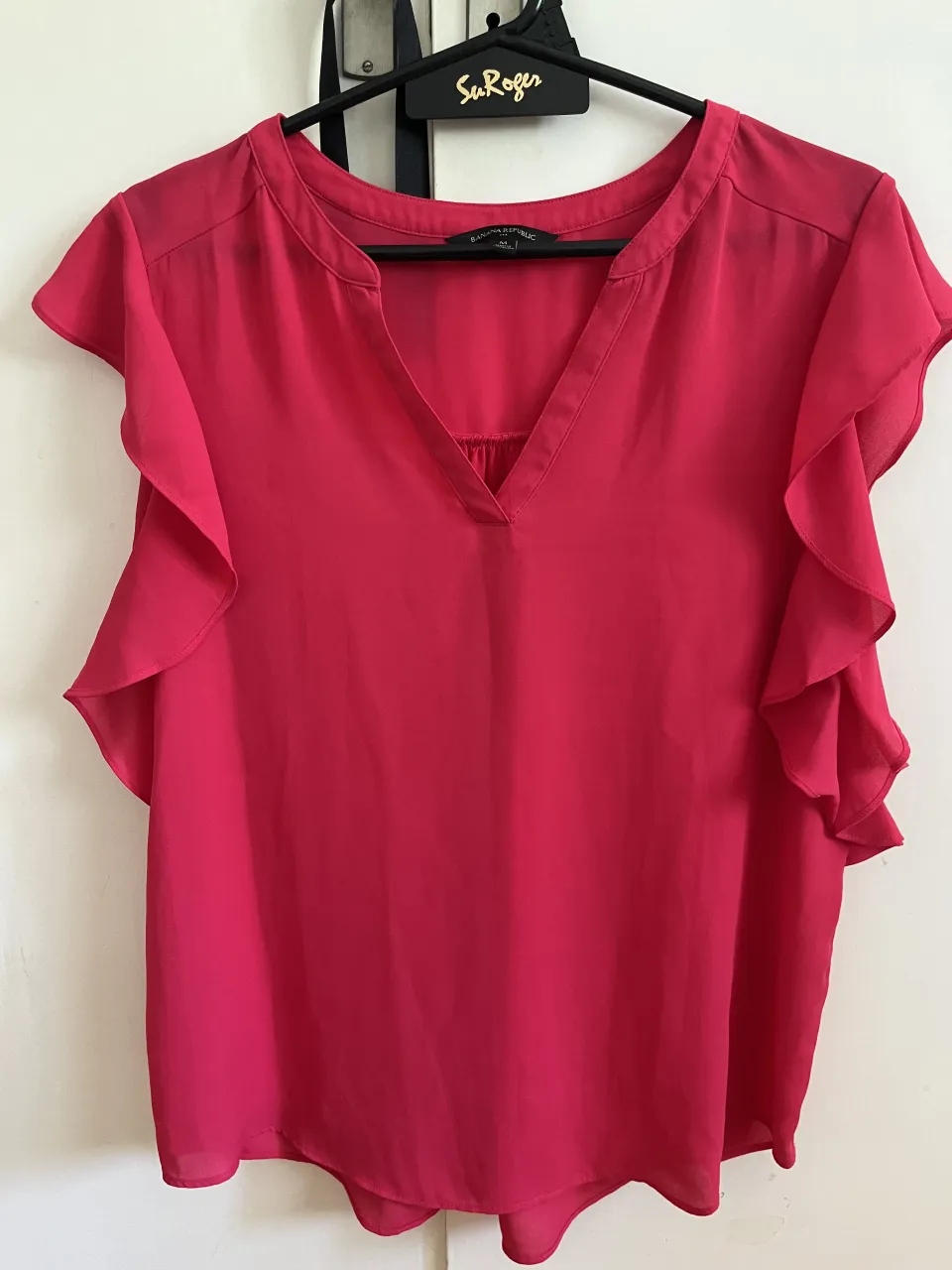 Blusa rosa vibrante con mangas acampanadas y escote en V. Perfecta para un look canchero y femenino.