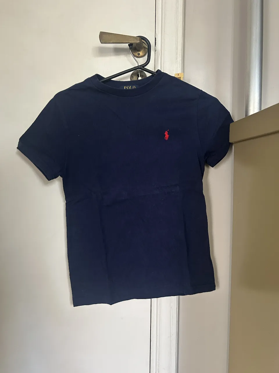Remera de hombre Polo Ralph Lauren azul marino, con el logo del jugador de polo bordado en rojo. Talle S (8). Ideal para un look casual y cómodo.