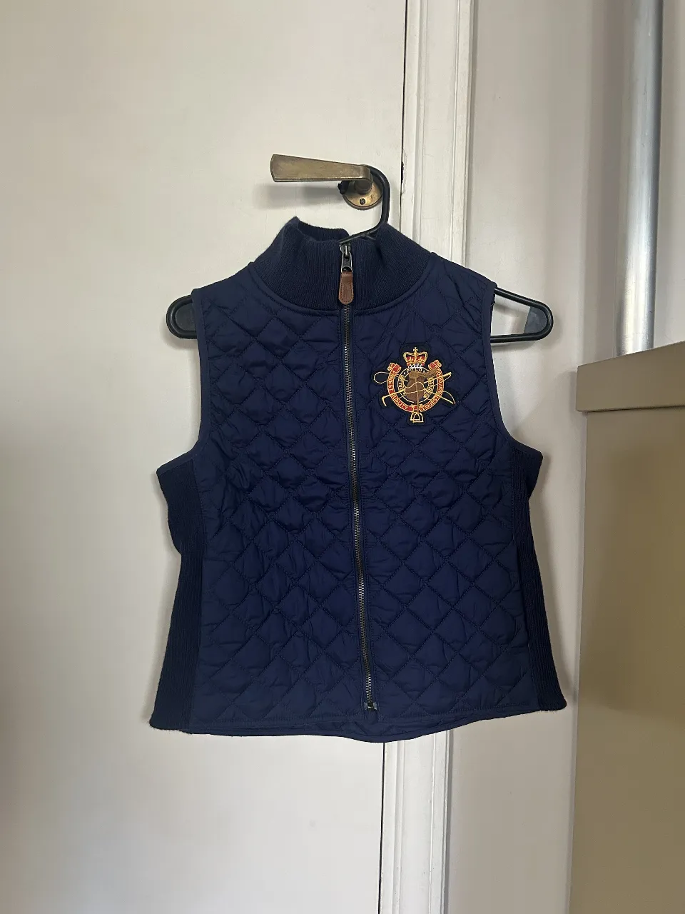 Chaleco acolchado azul marino de la marca Polo Ralph Lauren para hombre. Con cierre frontal, cuello alto y detalle del logo bordado en el pecho. Ideal para un look casual y abrigado.