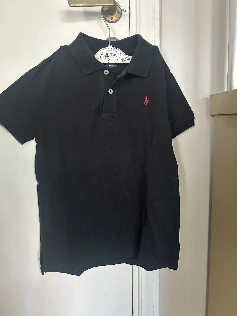 Remera polo negra de hombre, con el logo de Ralph Lauren bordado en rojo. Talle 7.