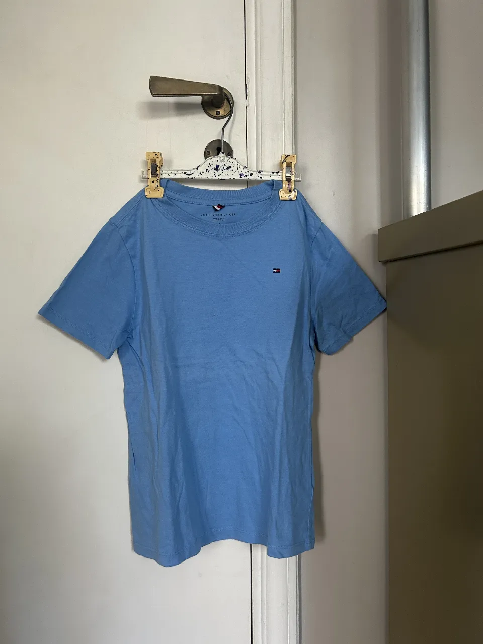 Remera Tommy Hilfiger azul, de manga corta, con el logo de la marca bordado en el pecho. Ideal para un look casual y cómodo.
