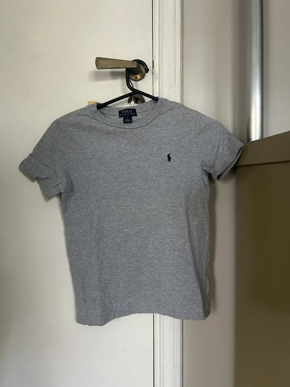 Remera gris de algodón con logo de Polo Ralph Lauren bordado en azul marino. Talle 7, ideal para niños.