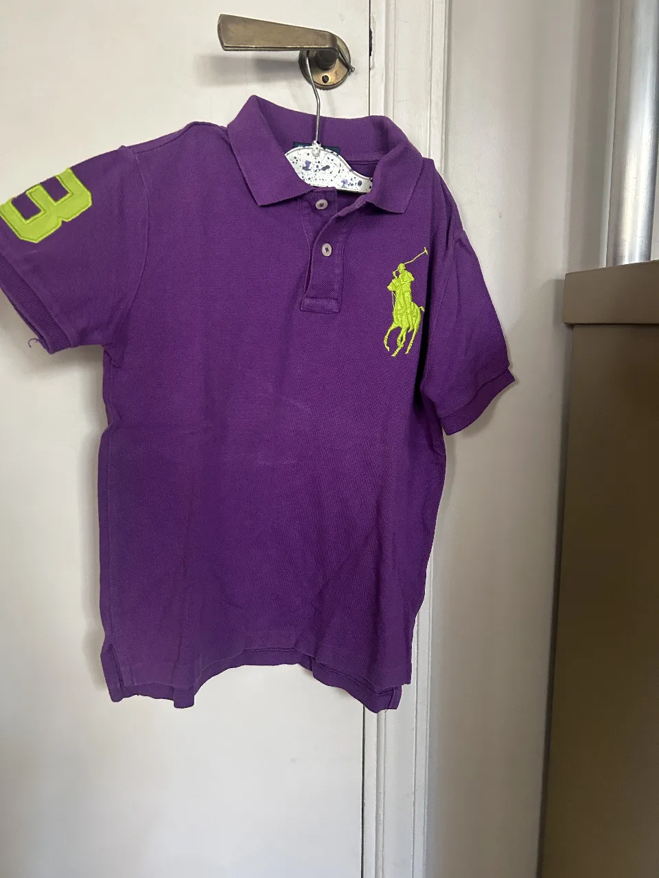 Remera polo Ralph Lauren para niño, color violeta con el logo verde en el pecho y el número 3 en la manga. Talle 7.