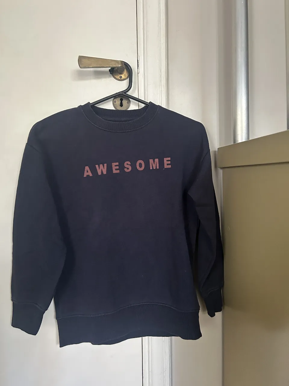 Buzo de cuello redondo azul marino para niño, con la palabra "AWESOME" en color borgoña. Talle 8, de la marca Zara Kids.