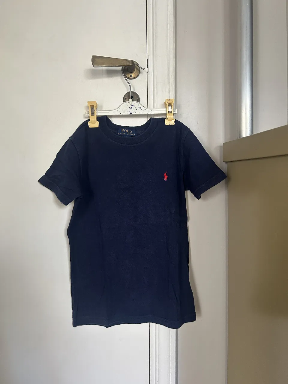 Remera Polo Ralph Lauren azul marino para niño, con el logo del jugador de polo bordado en rojo. Talle 7.