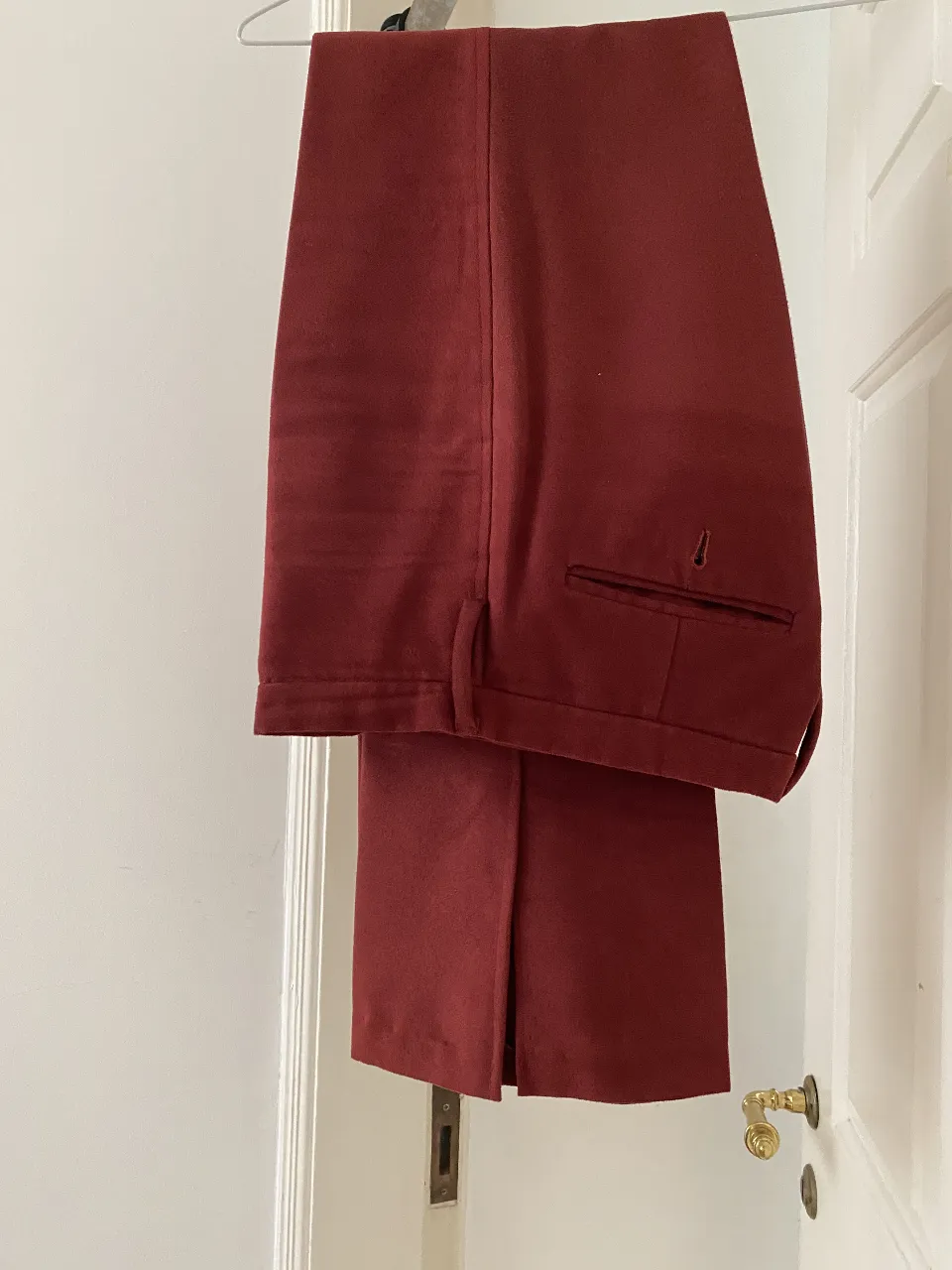 Pantalón sastrero Las Pepas, de color bordó. Confeccionado con tela de alta calidad, este pantalón con aberturas laterales ofrece un ajuste perfecto y un estilo atemporal. Perfecto para combinar con una camisa o un blazer. Simil gamuza.