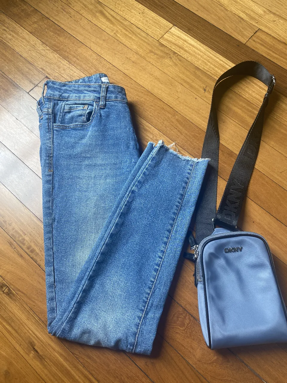 Jeans rectos de denim azul, con un corte clásico y detalles de desgaste en los bordes. Un básico versátil para cualquier guardarropa.