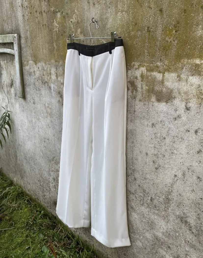 Pantalón Zara, sastrero blanco con detalle negro en la cintura. Corte amplio y elegante, ideal para un look sofisticado. Cintura 36cm.