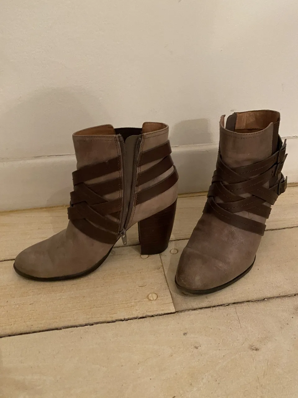 Botas de cuero con detalles de tiras cruzadas y cierre lateral. Taco ancho y cómodo. Ideales para un look casual y canchero. Color visón/chocolate