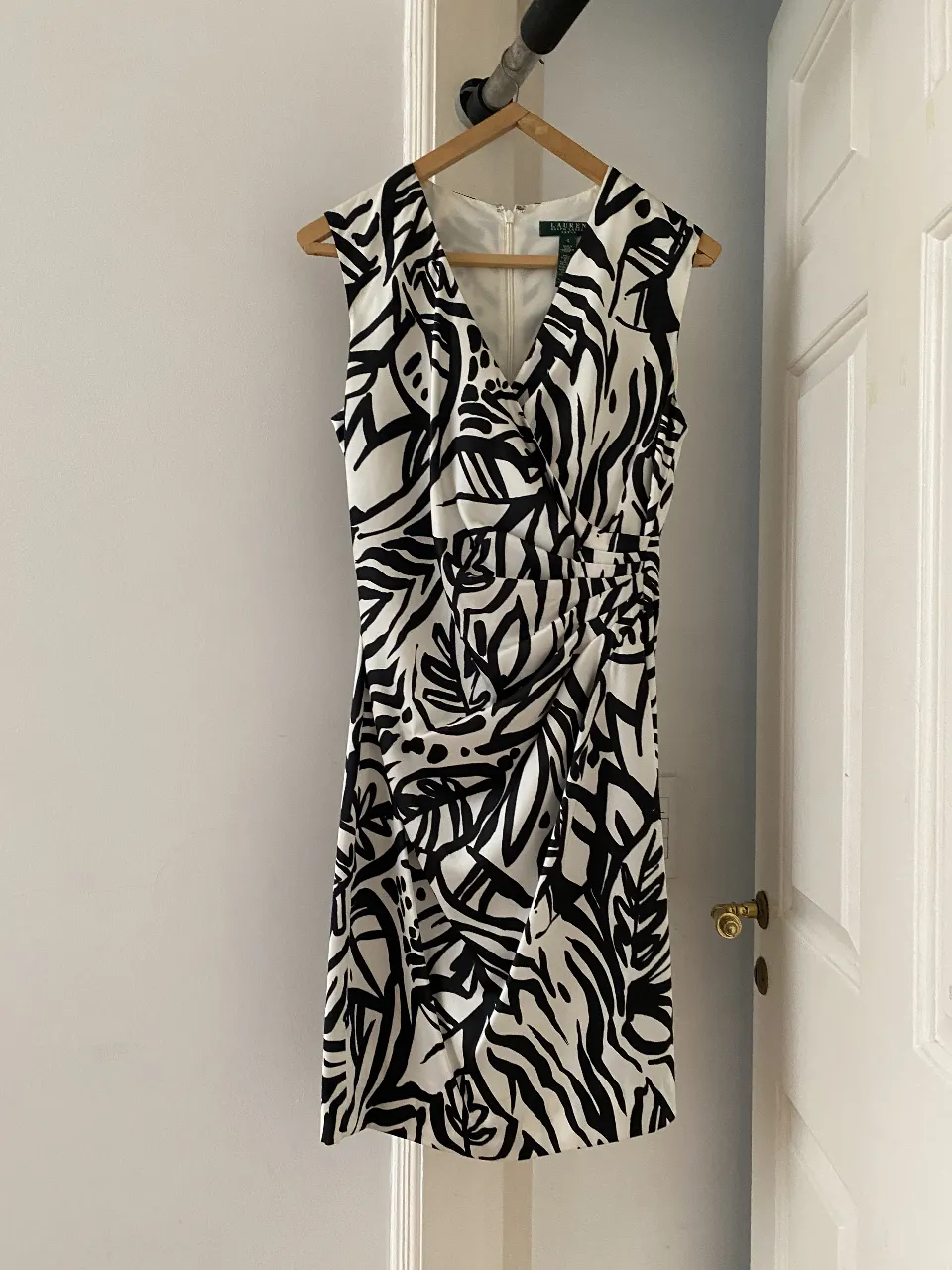 Vestido de Lauren, con estampado abstracto en blanco y negro. Corte cruzado en el busto y detalle fruncido en la cintura. Ideal para eventos formales o salidas.