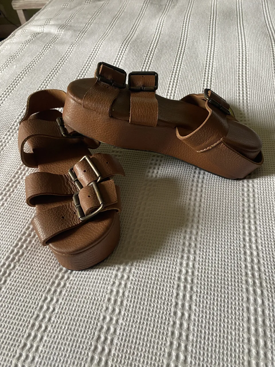 Sandalias de cuero marrón con plataforma y hebillas. Ideales para un look casual y cómodo.