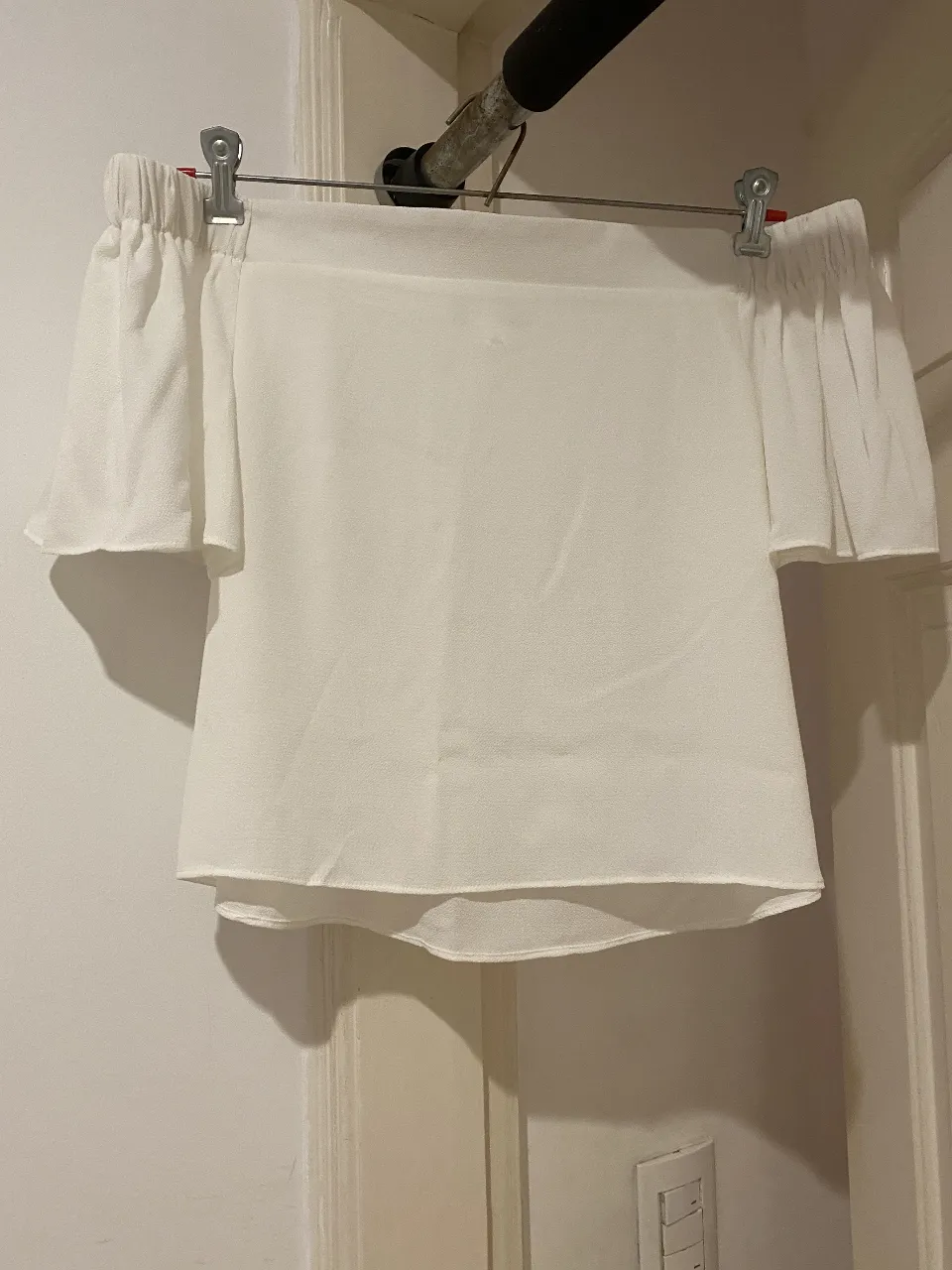 Blusa blanca off shoulder, ideal para un look fresco y elegante. Con mangas cortas y detalles fruncidos, perfecta para combinar con jeans o faldas.