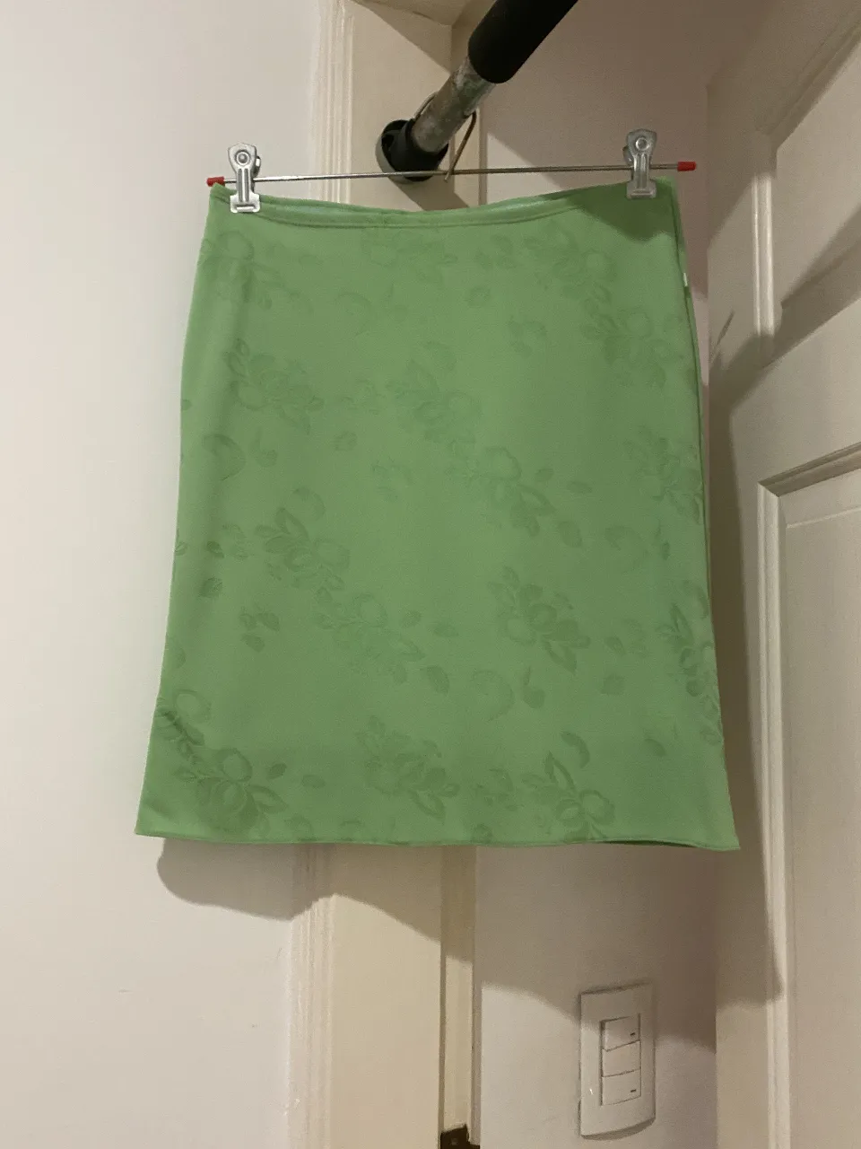 Pollera sobre rodilla de color verde claro con estampado floral en relieve. Ideal para un look fresco y femenino.