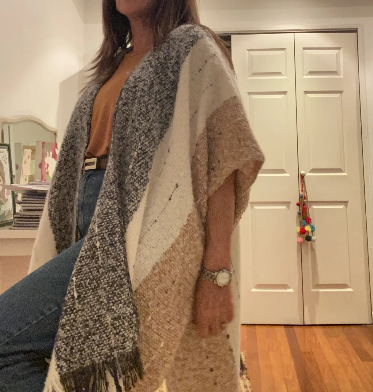 Poncho tejido a rayas en tonos neutros, ideal para el invierno. Con flecos en el borde inferior, perfecto para un look boho y abrigado.Talle Unico.