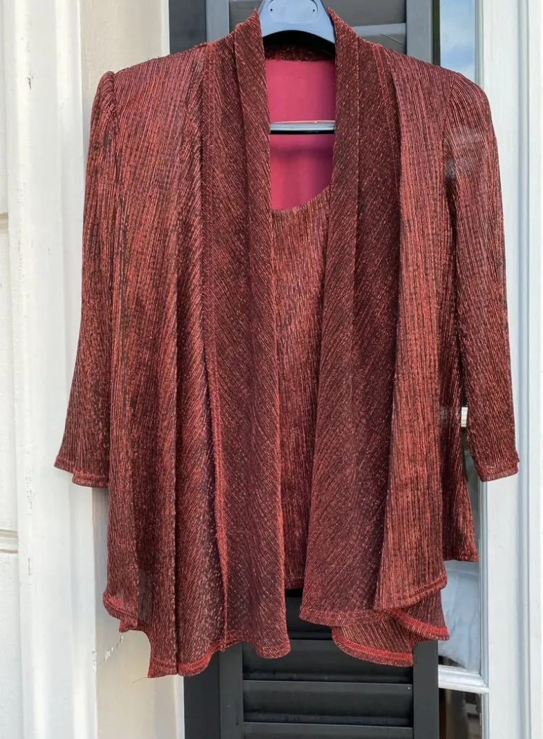 Conjunto de fiesta comouesto de cardigan con musculosa incorporada de tela metalizada brillosa en tono rojo oscuro. Ideal para un look elegante y sofisticado.