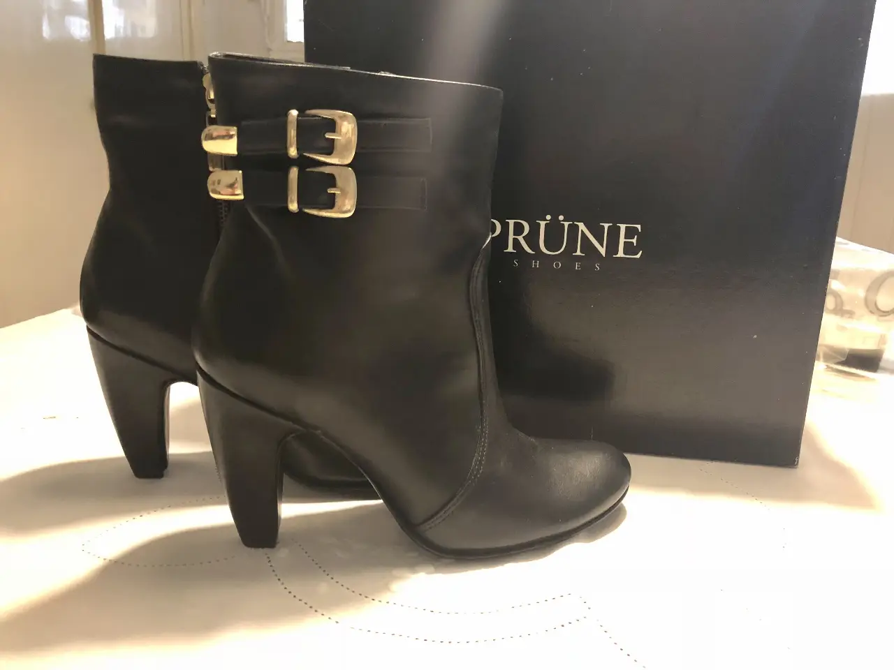 Botas de cuero negro con detalles dorados y hebillas. Ideales para un look elegante y sofisticado.