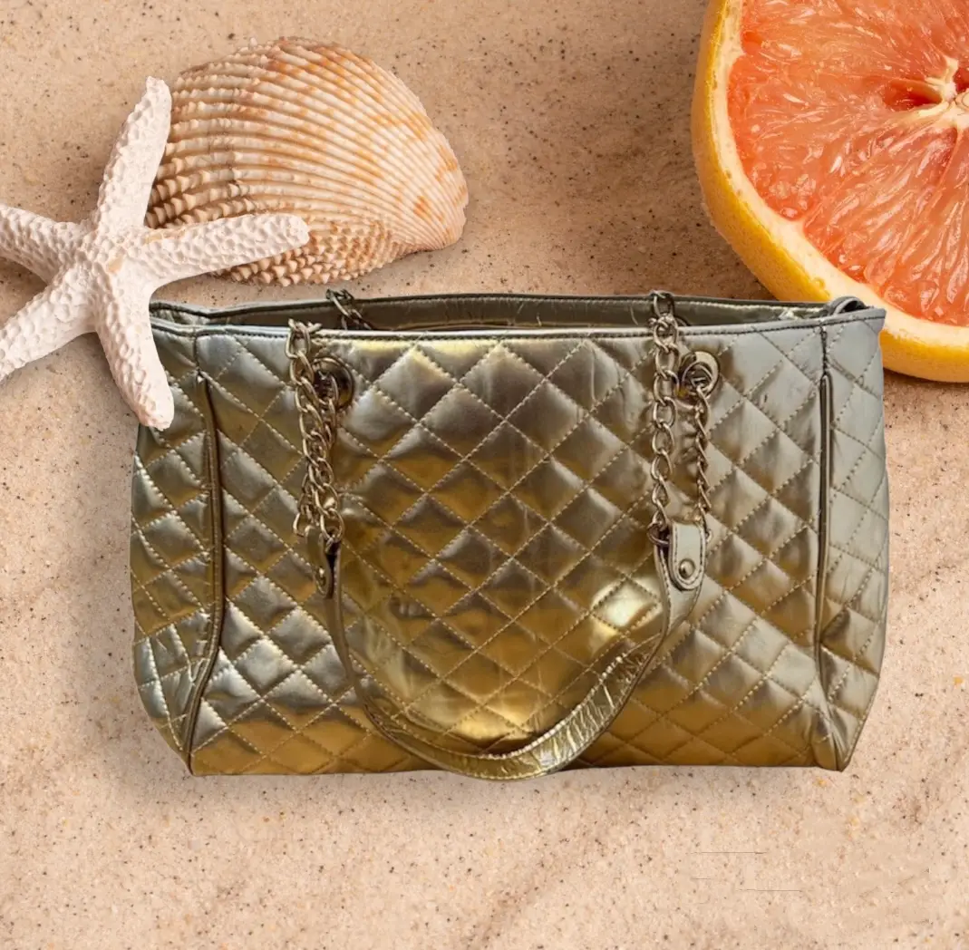Cartera dorada acolchada con cadena dorada. Ideal para un look elegante y sofisticado.