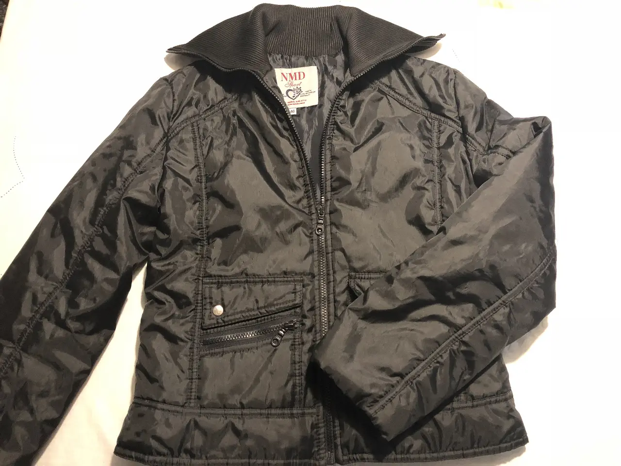 Campera negra de mujer, con cuello alto y cierre. Ideal para el invierno, con bolsillos y un diseño moderno.