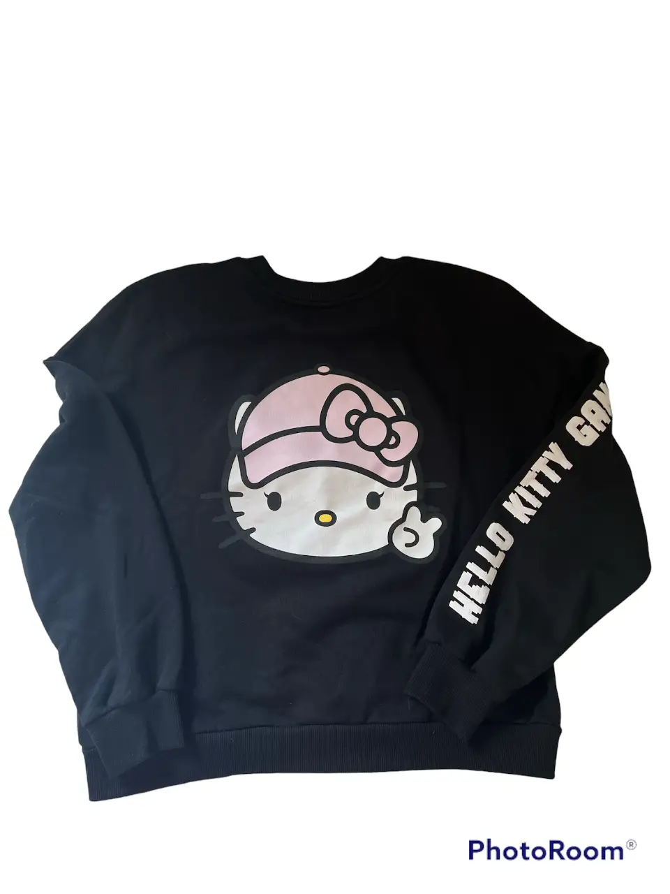 Buzo Bershka de cuello redondo negro de Hello Kitty con estampado en el frente y detalle de texto en la manga. Ideal para un look casual y cómodo.