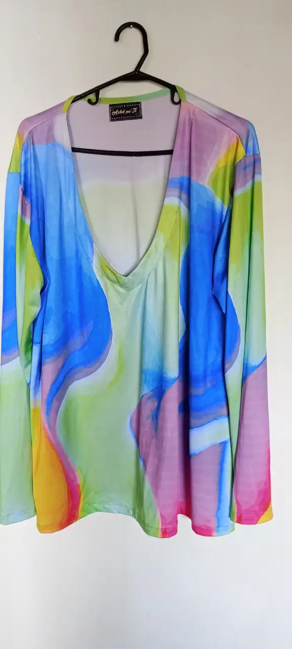 Remera de manga larga con estampado abstracto en tonos azules, verdes, rosas y amarillos. Cuello en V. Ideal para un look moderno y llamativo.