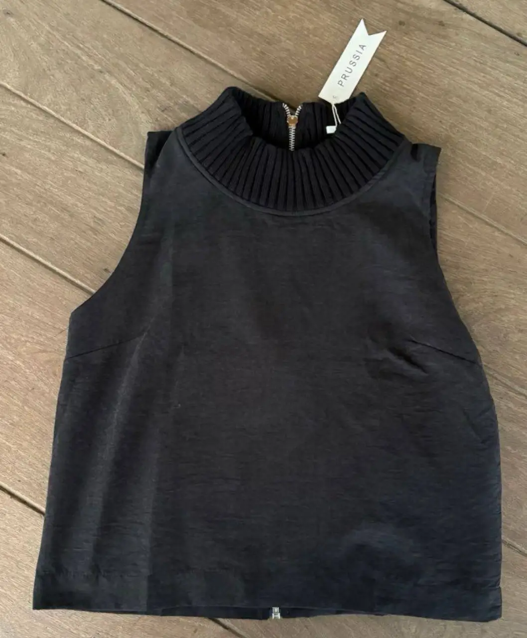Top negro con cuello alto y cierre en la espalda de microfibra plana gamuzada. Ideal para un look elegante y moderno. Perfecto para combinar con pantalones de vestir o faldas.