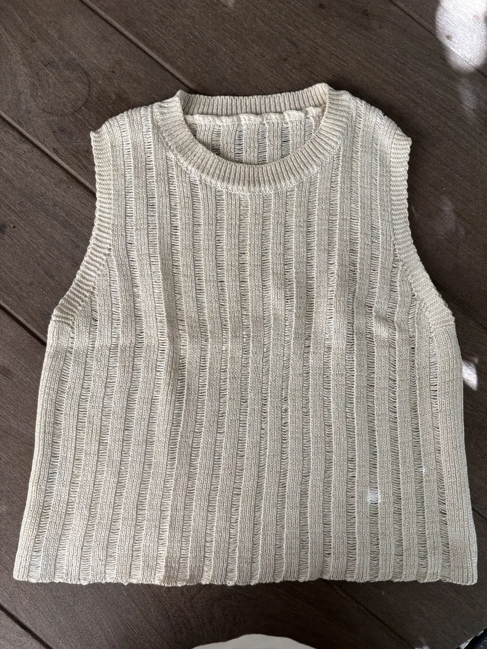 Musculosa tejida de hilo, con diseño calado y textura acanalada. Ideal para un look fresco y moderno.