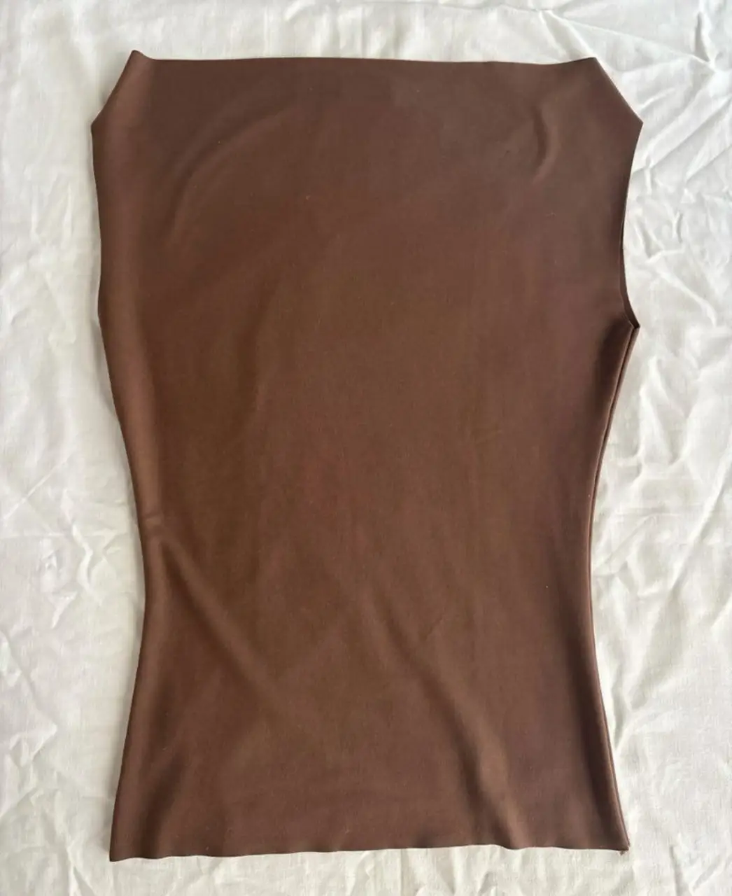 Top marrón de diseño elegante y moderno, ideal para un look sofisticado. Confeccionado en un tejido suave y adaptable, este top sin mangas ofrece un ajuste favorecedor y cómodo. Perfecto para combinar con faldas o pantalones de cintura alta, este top es una pieza clave para cualquier guardarropa.
