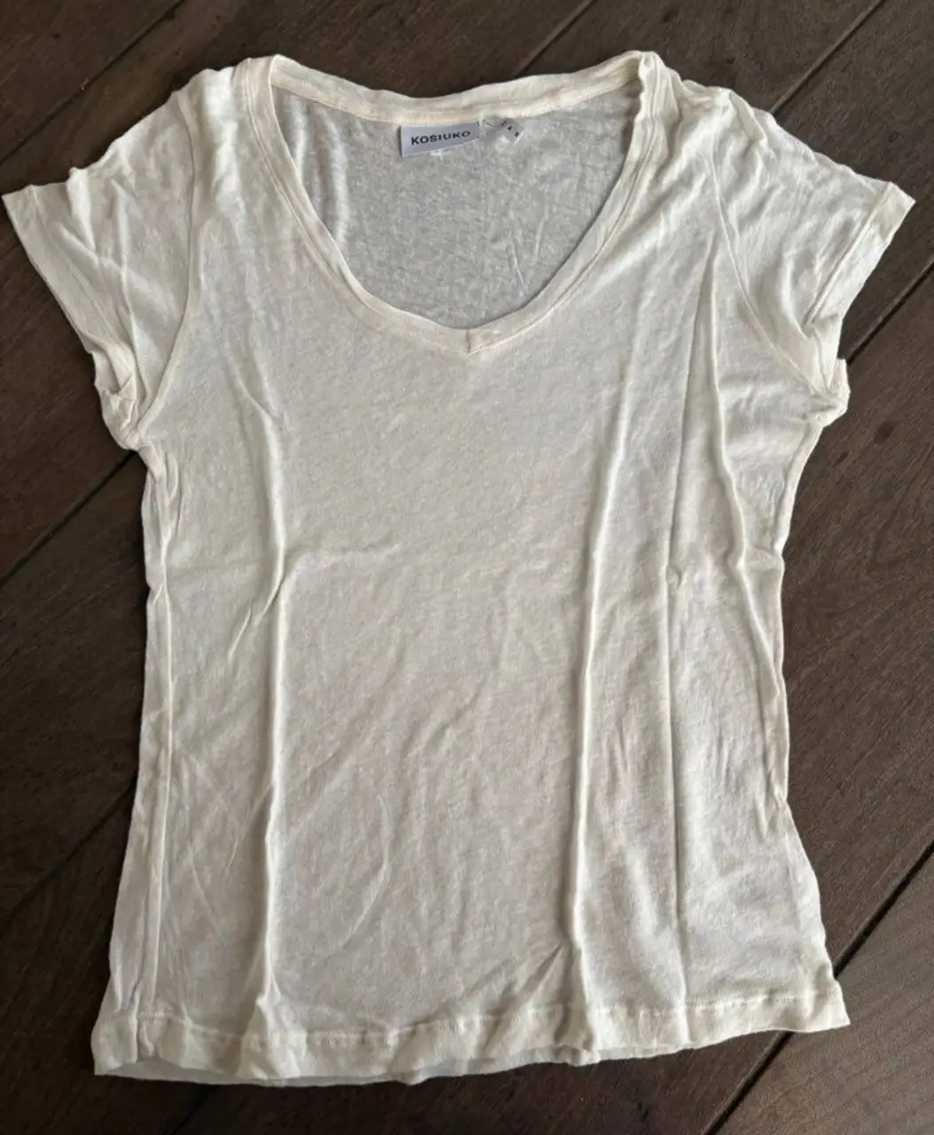 Remera blanca de mujer, con cuello en V, de la marca Kosiuko. Ideal para un look casual y cómodo. 40% lino 