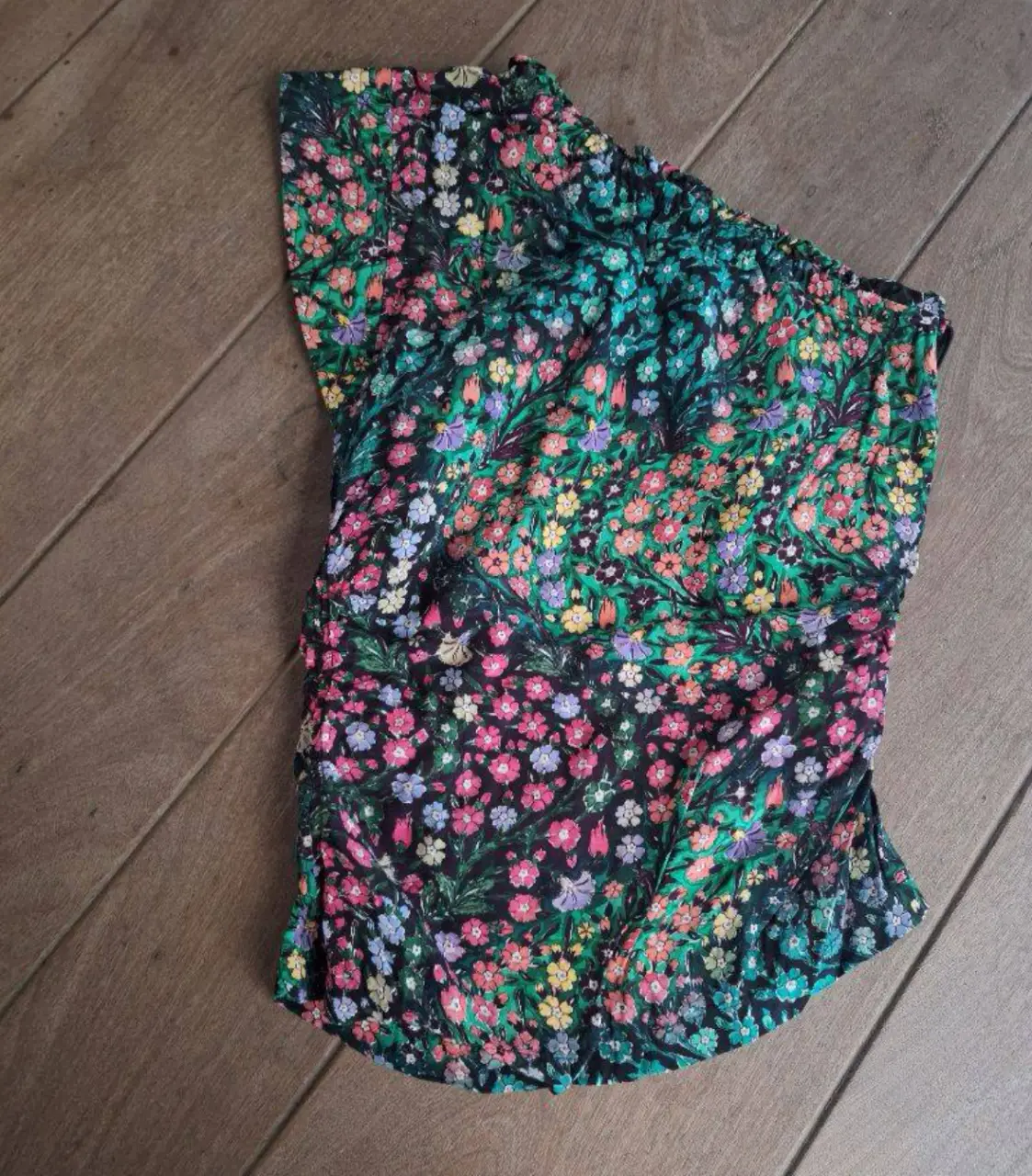 Top de mujer con estampado floral en tonos oscuros y detalles fruncidos. Un hombro descubierto y forro  interno. Ideal para un look fresco y moderno.