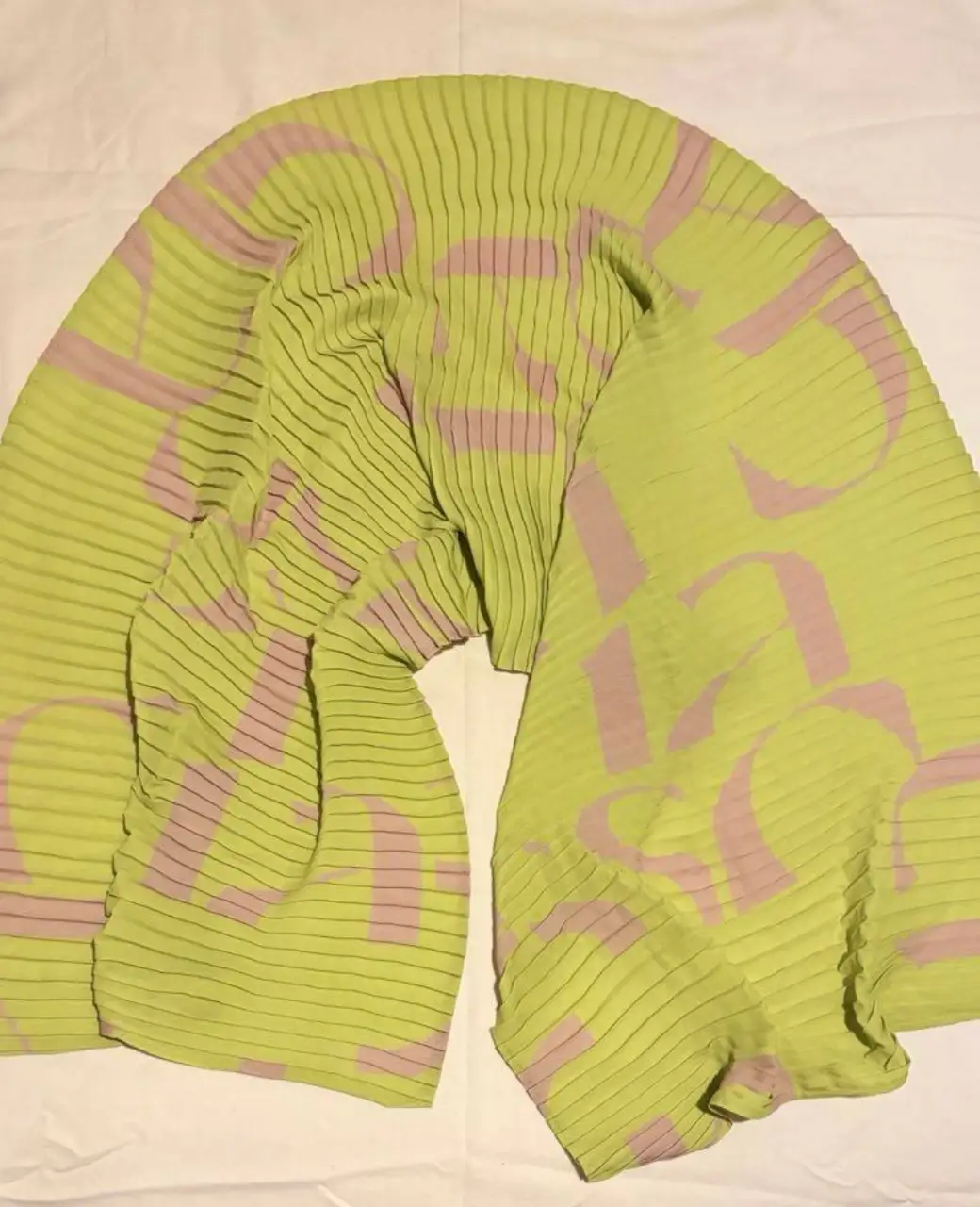 pañuelo de gasa plisada de color verde lima con estampado de letras en rosa. Ideal para darle un toque de color y estilo a cualquier look. Marca Lasso. 45x145cm