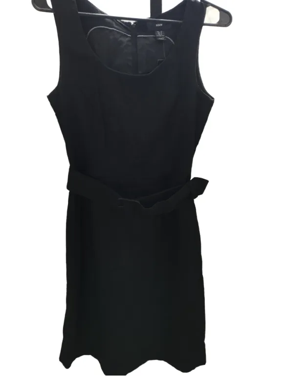 Vestido negro de H&M, sin mangas y con cinturón. Ideal para un look elegante y sofisticado.