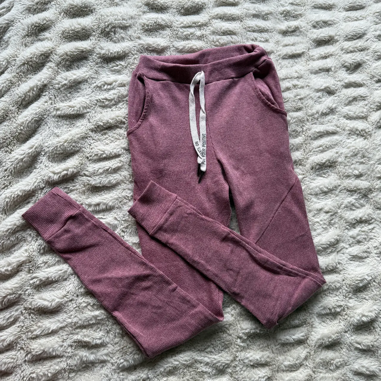 Pantalón de jogging de mujer, color rosa, con cintura elastizada y cordón. Bolsillos laterales y puños en los tobillos. Ideal para un look cómodo y casual.