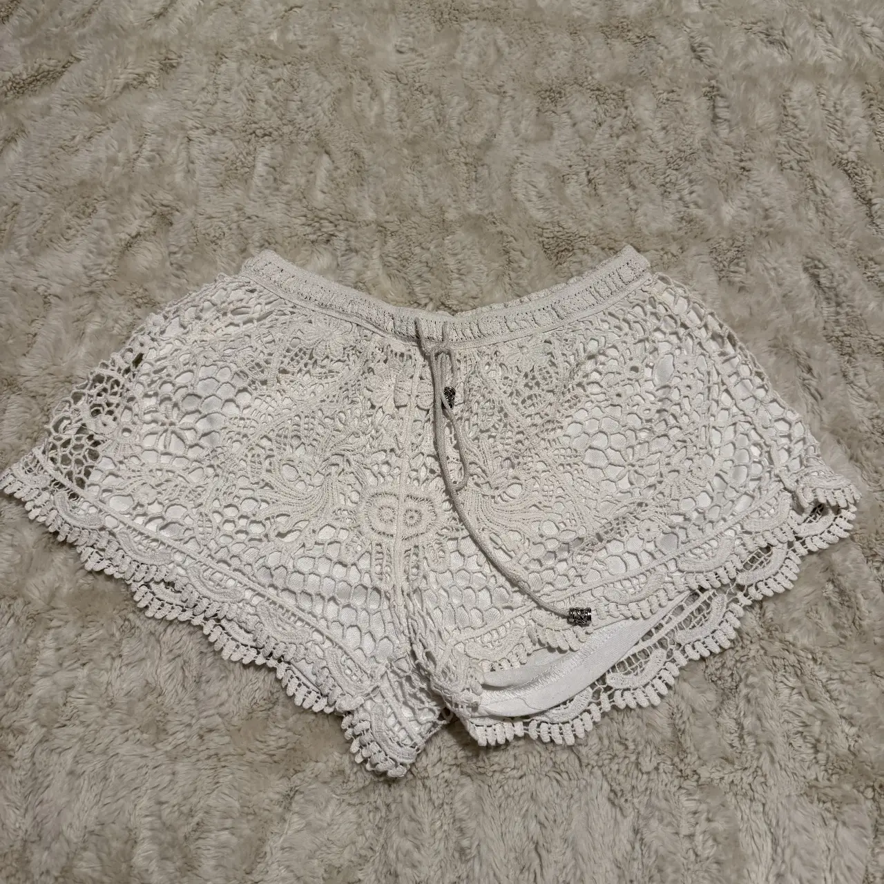 Shorts de encaje blanco, ideales para un look boho chic. Perfectos para el verano, estos shorts tejidos son cómodos y estilosos.