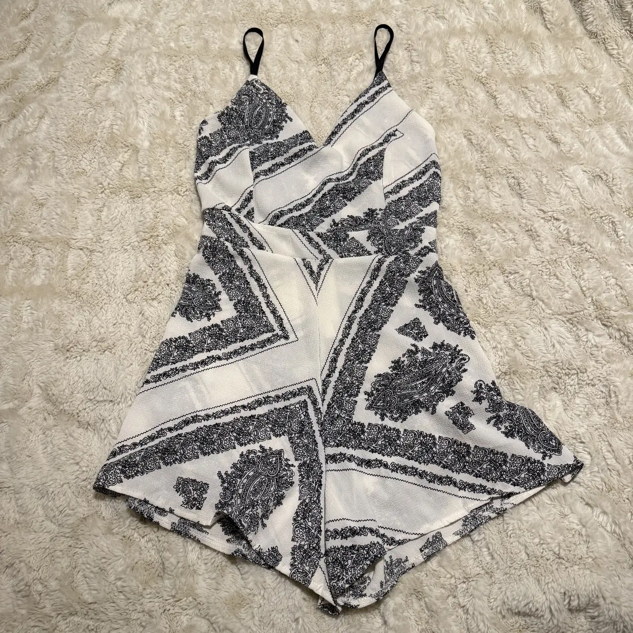 Mono corto de mujer con estampado geométrico en blanco y negro. Ideal para el verano, con tirantes finos y escote en V.