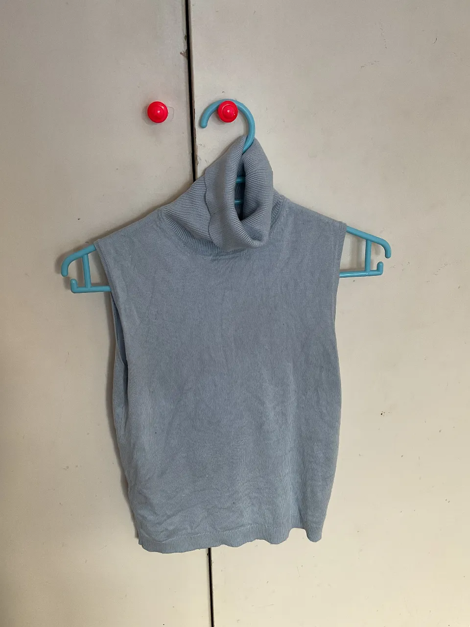 Remera sin mangas de cuello alto en color celeste, ideal para combinar con diferentes outfits. Perfecto para un look casual y moderno.
