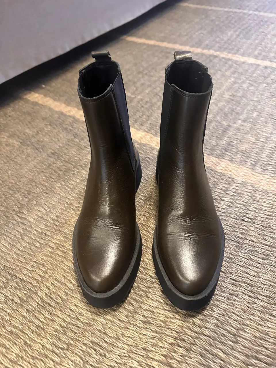 Botines de cuero marrón oscuro de la marca Anthropologie. Diseño elegante y versátil, ideales para complementar cualquier outfit de invierno.